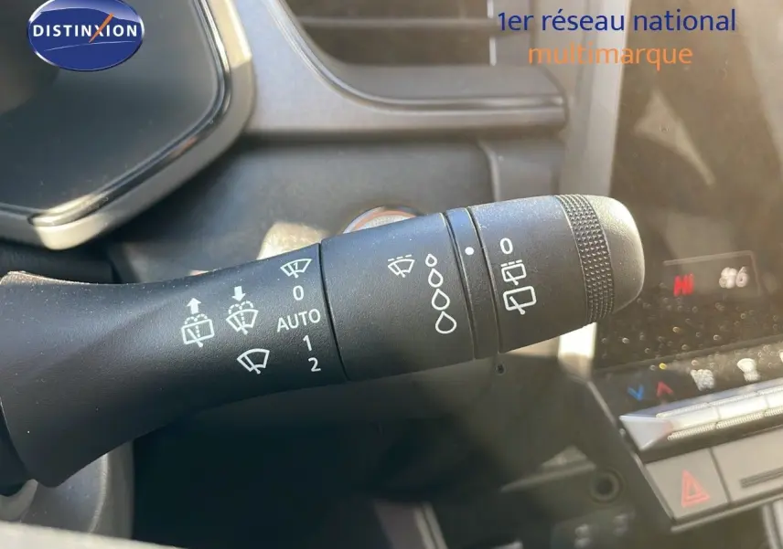 Gros plan sur la commande des essuie-glaces du Renault Captur gris Rafale, intérieur avec tableau de bord partiellement visible.