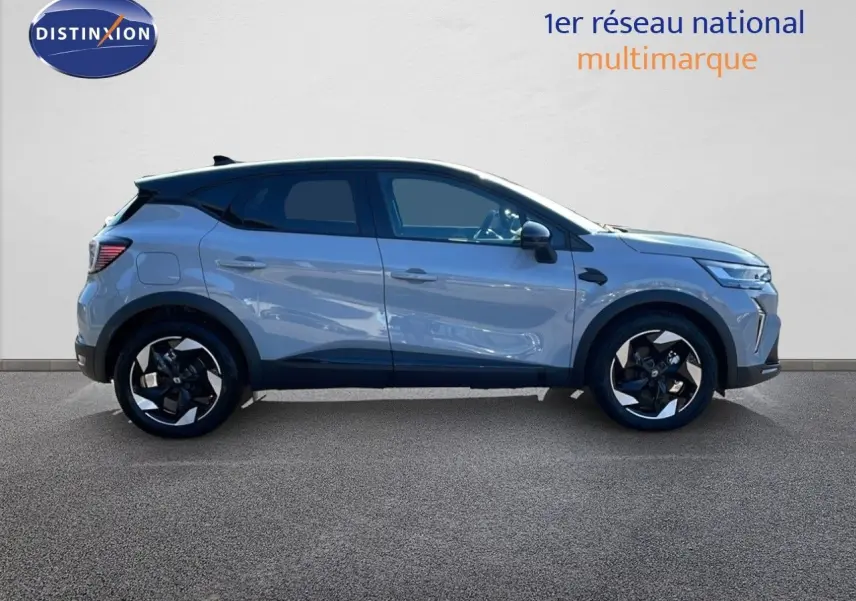 Profil droit du Renault Captur E-Tech hybride 2025 gris Rafale avec toit noir et jantes bicolores distinctives.