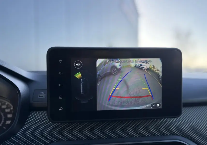 Écran tactile intérieur montrant la caméra de recul du Dacia Jogger gris schiste avec lignes de guidage colorées.