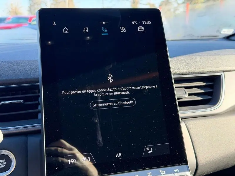 Écran tactile central du Renault Captur 2025 affichant la connexion Bluetooth, intérieur clair avec aérateurs visibles.