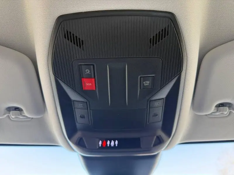 Vue en contre-plongée du panneau de commandes au plafond du Peugeot 308 gris, avec bouton SOS rouge bien visible.