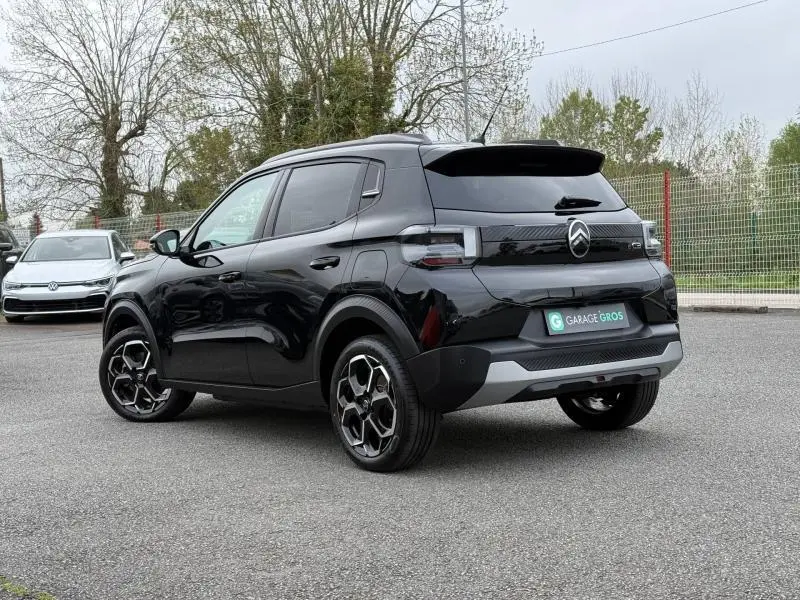 Citroën C3 électrique 2025 noir Perla Nera vue 3/4 arrière droit avec jantes distinctives et logo lumineux.