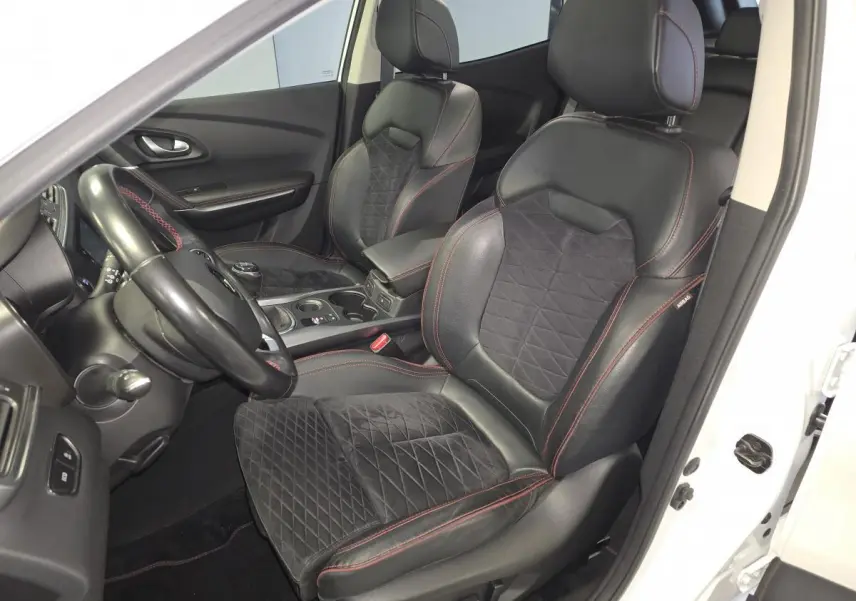 Vue intérieure côté conducteur du Renault Kadjar blanc, sièges mixte cuir/Alcantara noirs avec surpiqûres rouges et volant cuir.