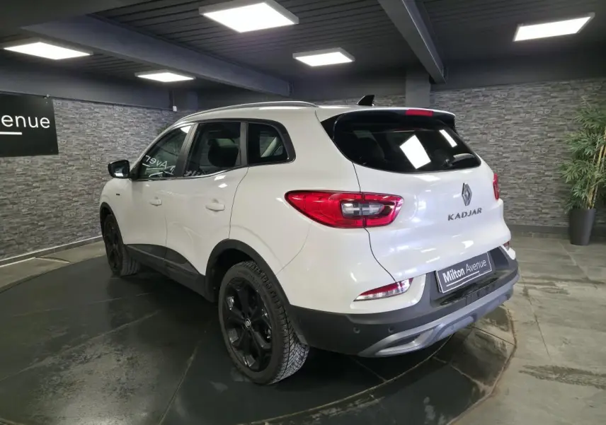 Vue 3/4 arrière droite du Renault Kadjar blanc nacré Black Edition avec jantes alliage noires en showroom.