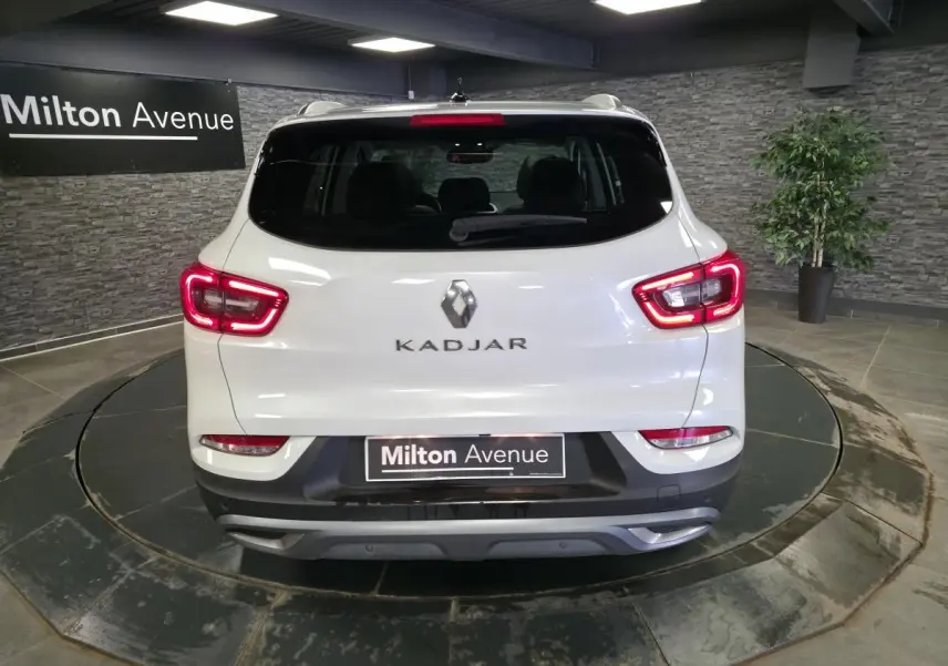 Vue arrière d'un Renault Kadjar blanc nacré 2020 avec feux LED allumés dans un showroom intérieur.