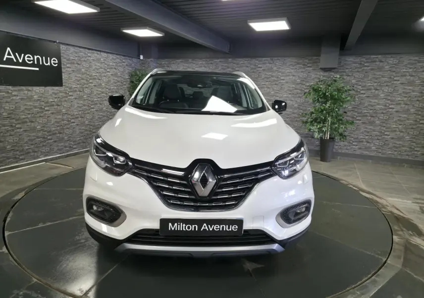 Vue avant d'un Renault Kadjar blanc nacré 2020 avec calandre noire et phares LED dans un showroom.
