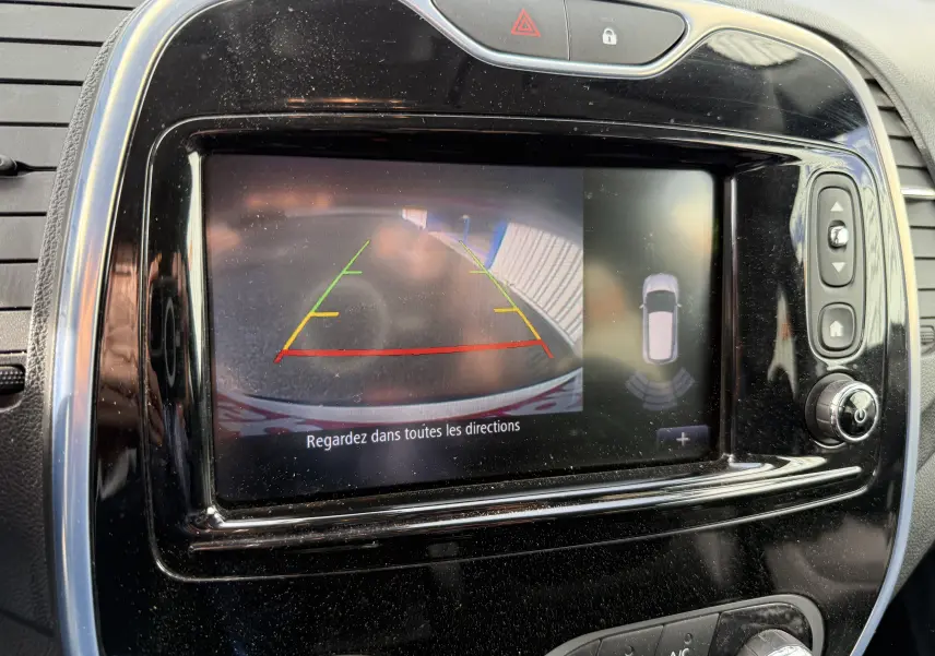 Écran central de Renault Captur blanc 2017 montrant la caméra de recul avec lignes de guidage colorées et vue 360° du véhicule.