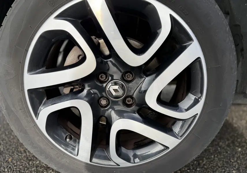 Gros plan sur la jante alliage bicolore noire et argent avec logo Renault au centre du Renault Captur blanc 2017.