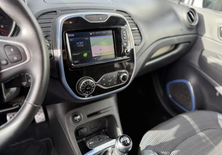 Intérieur Renault Captur blanc 2017, vue côté conducteur sur tableau de bord avec écran tactile et levier de vitesse manuel.