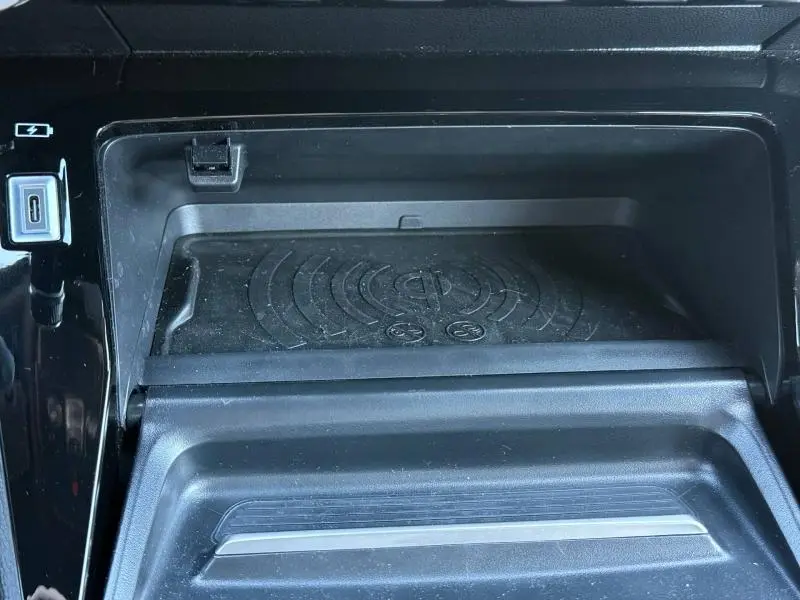 Gros plan sur le compartiment de recharge sans fil et port USB-C du Peugeot 2008 bleu Obsession 2025.