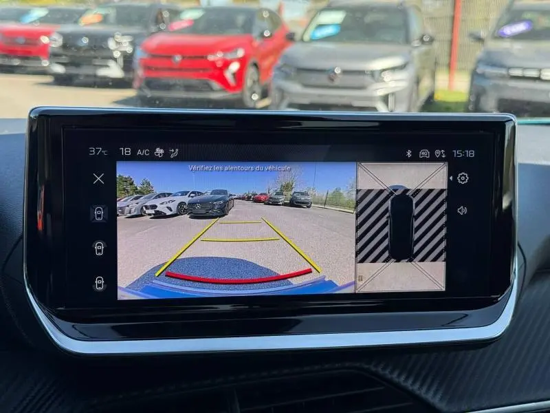 Vue caméra de recul du Peugeot 2008 bleu Obsession, montrant l’arrière en stationnement avec lignes de guidage jaunes et rouges.