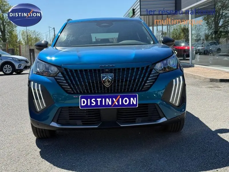 Vue frontale d'un Peugeot 2008 1.2 Hybrid 145ch Allure bleu Obsession avec signature lumineuse verticale LED.