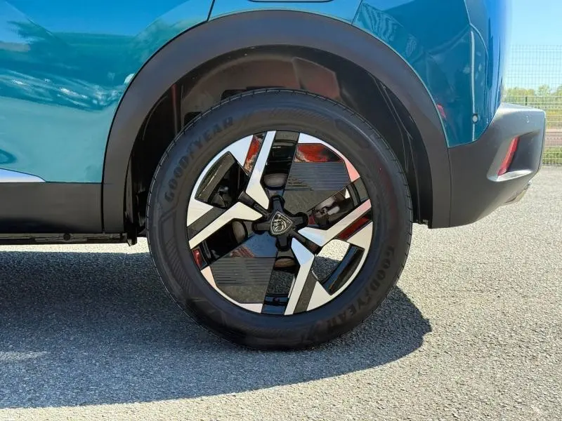 Gros plan sur la roue arrière droite d’un Peugeot 2008 Bleu Obsession 2025 avec jante alliage bicolore et pneu Goodyear.