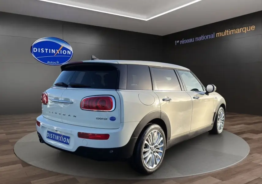 Vue 3/4 arrière droite d'une MINI Clubman Cooper Exquisite blanche avec jantes alliage et feux arrière LED.