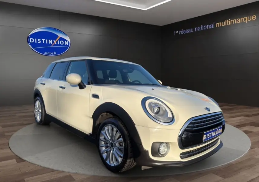 MINI CLUBMAN Cooper Exquisite blanc vue 3/4 avant droit, avec phares ronds et calandre chromée distinctive.