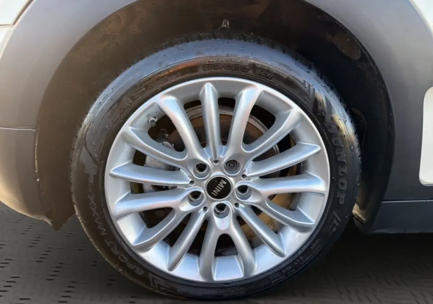 Gros plan sur la jante alliage argentée de la roue avant droite d'une MINI Clubman blanche, avec pneu Dunlop.