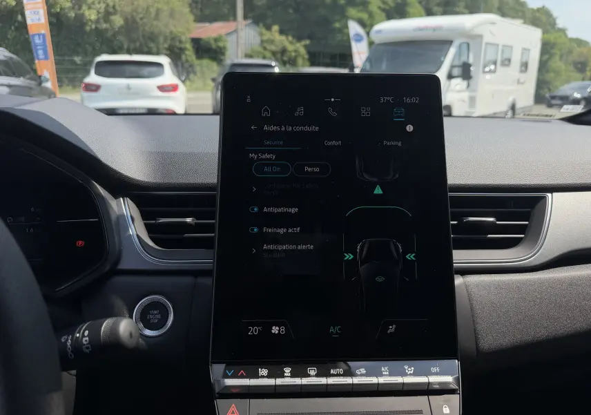 Vue intérieure centrée sur l’écran tactile vertical du tableau de bord du Renault Captur gris Cassiopée bi-ton, affichant les aides à la conduite.