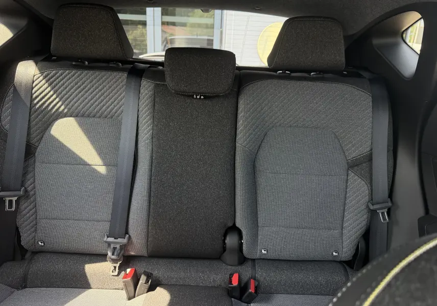 Vue arrière intérieure des sièges arrière gris foncé du Renault Captur 1.8 E-Tech Full Hybrid 160 Techno, avec ceintures et appuie-têtes.