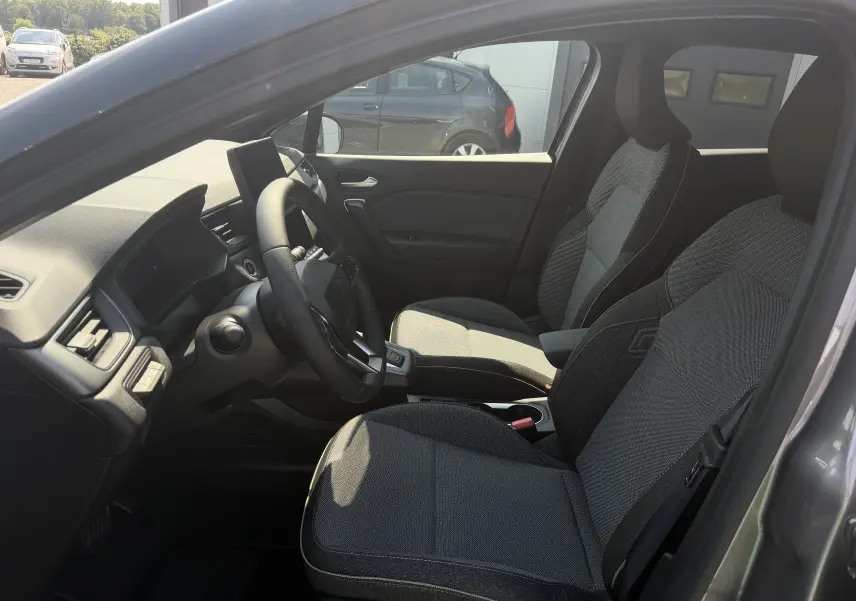 Vue intérieure côté conducteur du Renault Captur gris Cassiopée, avec sièges Techno et volant textile grainé.