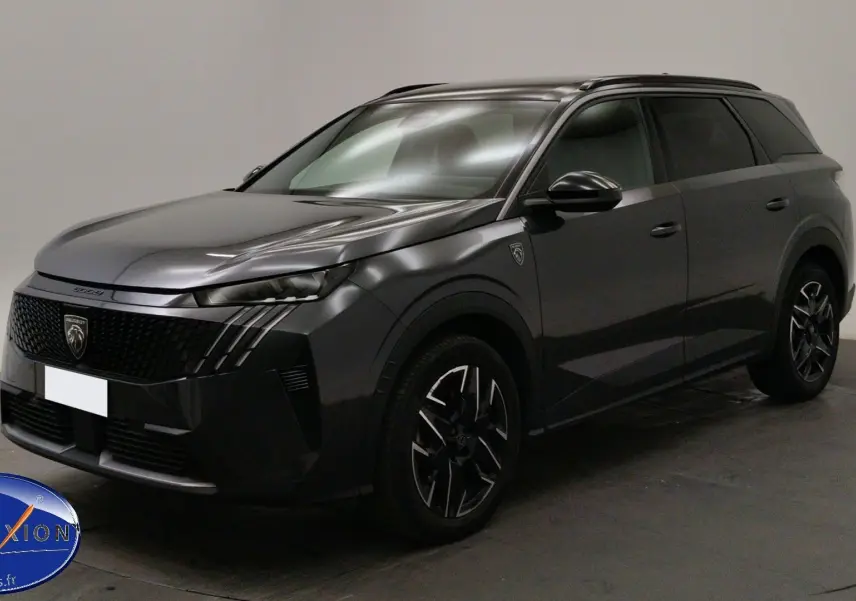 Peugeot 5008 III Hybrid gris titane en 3/4 avant droit, mettant en valeur sa calandre distinctive et ses jantes bi-ton.