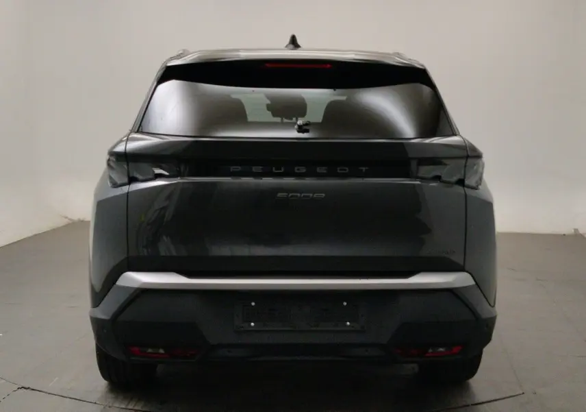 Vue arrière d’un Peugeot 5008 III Hybrid 145 gris titane avec feux arrière noirs et lunette teintée.