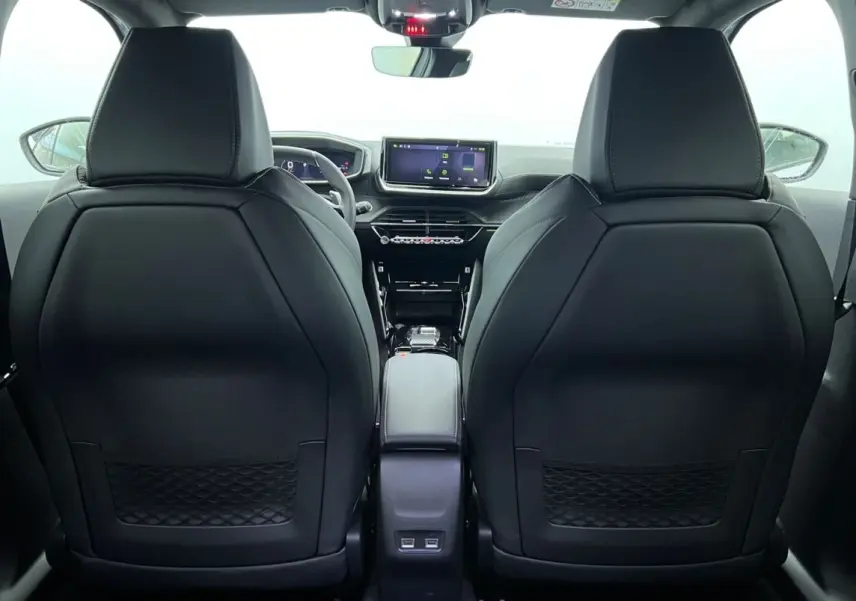 Vue arrière de l’intérieur noir du Peugeot 2008 Hybrid 145 GT, avec écran tactile central et sièges avant en cuir.