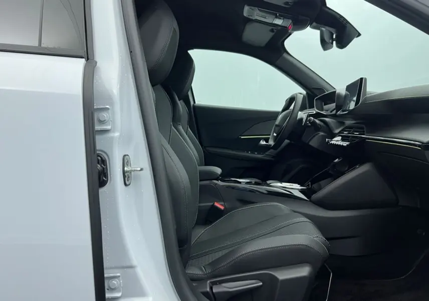 Intérieur côté conducteur du Peugeot 2008 Hybrid blanc 2025, sièges noirs et tableau de bord moderne avec écran tactile.
