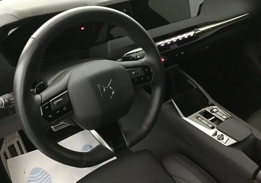 Intérieur noir du DS4 2022 vu côté conducteur, volant compact avec logo DS et console centrale moderne aux finitions soignées.