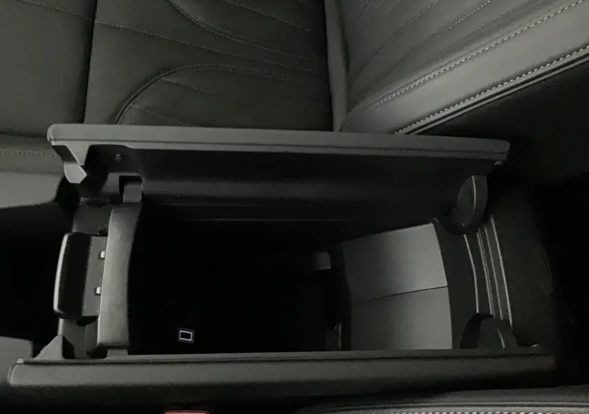 Gros plan sur l'accoudoir central ouvert en cuir noir du DS4 2022, révélant un espace de rangement intérieur.