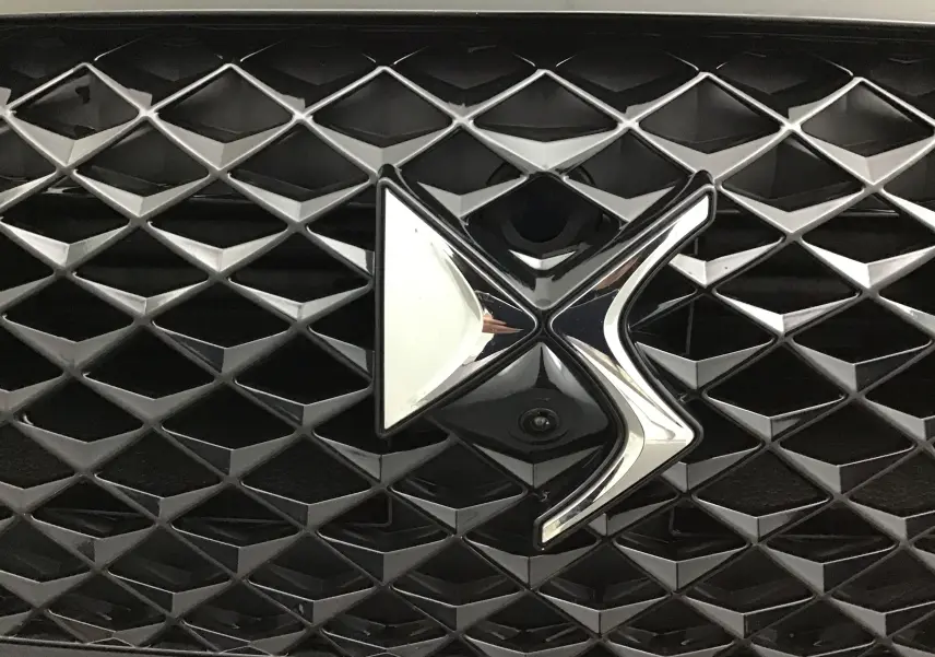 Gros plan sur la calandre noire du DS4 2022 avec le logo DS chromé en relief au centre.