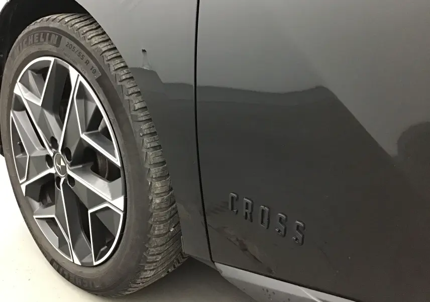 Gros plan sur la roue avant gauche et l'inscription CROSS sur la carrosserie noire du DS4 Cross Rivoli 2022.