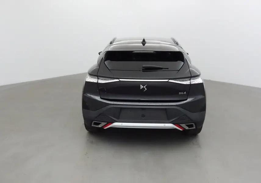 Vue arrière d'une DS4 noire 2022 avec feux effilés et double sortie d'échappement intégrée au pare-chocs.