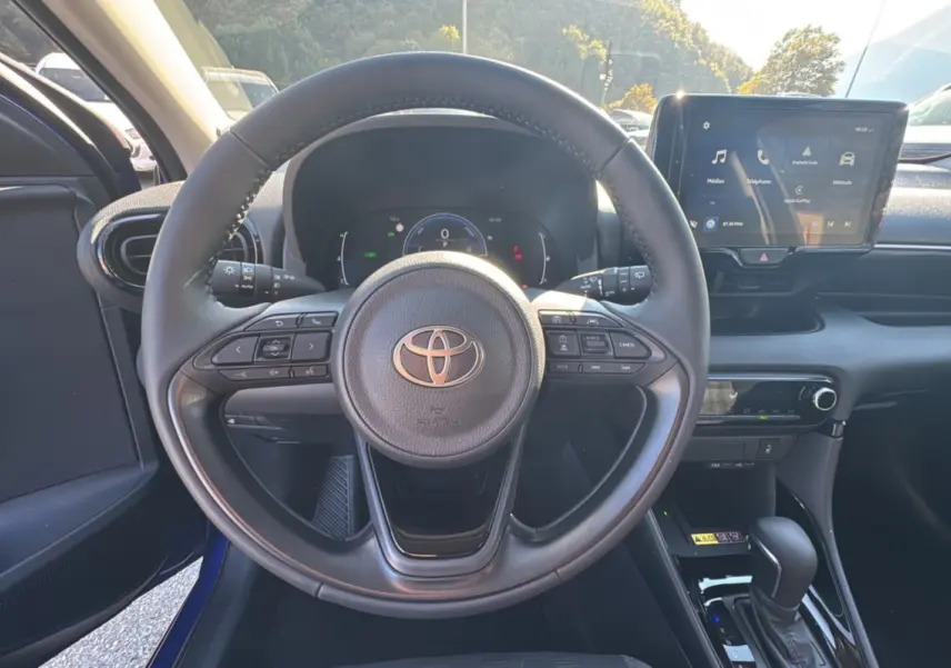 Vue centrée sur le volant et le tableau de bord de la Toyota Yaris 1.5 Hybrid 116 BVA Design 2025, intérieur noir.
