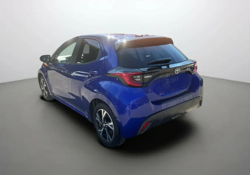 Toyota Yaris 1.5 Hybrid 2025 bleu genièvre vue 3/4 arrière droit avec feux arrière distinctifs noirs.