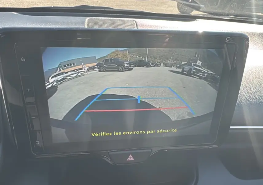 Écran de caméra de recul affichant une vue arrière dégagée avec lignes de guidage colorées dans une Toyota Yaris 2025 bleu genievre.