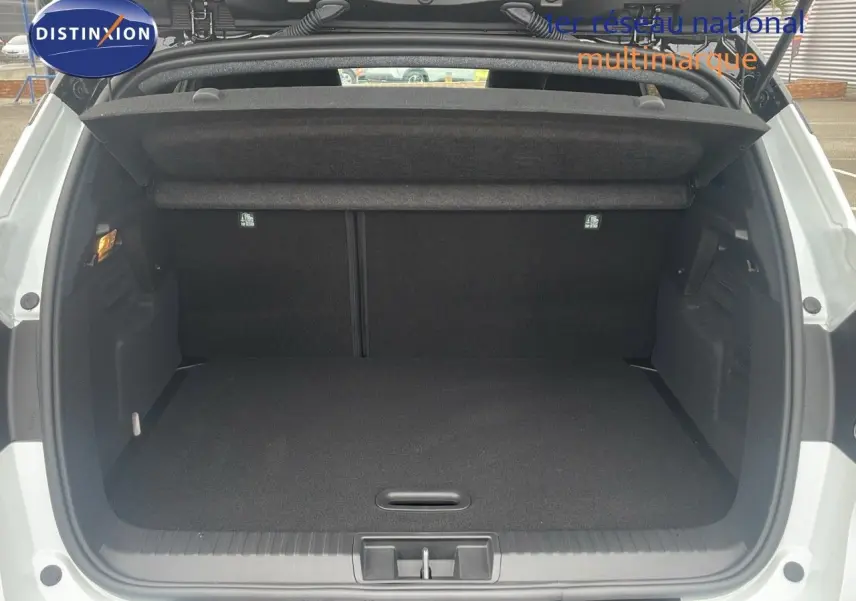 Coffre ouvert vu de l'arrière d'un Renault Captur blanc nacré au toit noir, montrant un espace de chargement propre et spacieux.