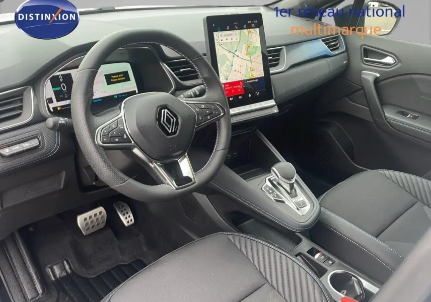 Intérieur avant droit du Renault Captur E-Tech hybride 2025, tableau de bord moderne avec écran tactile vertical et volant multifonction.