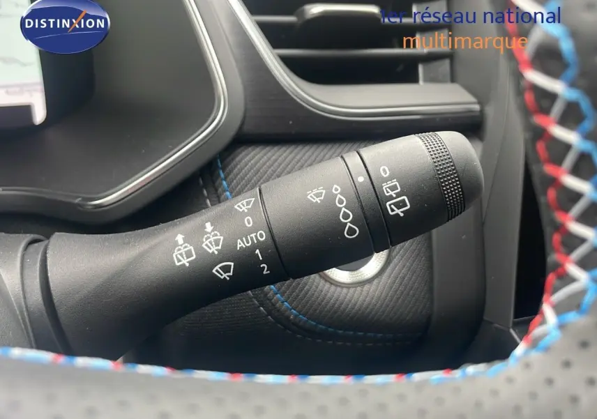 Gros plan sur la commande d'essuie-glace du Renault Captur E-Tech blanc nacré, avec surpiqûres bleues visibles.