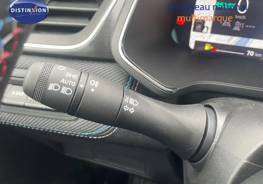 Gros plan sur la commande des feux et clignotants du tableau de bord du Renault Captur blanc nacré 2025.