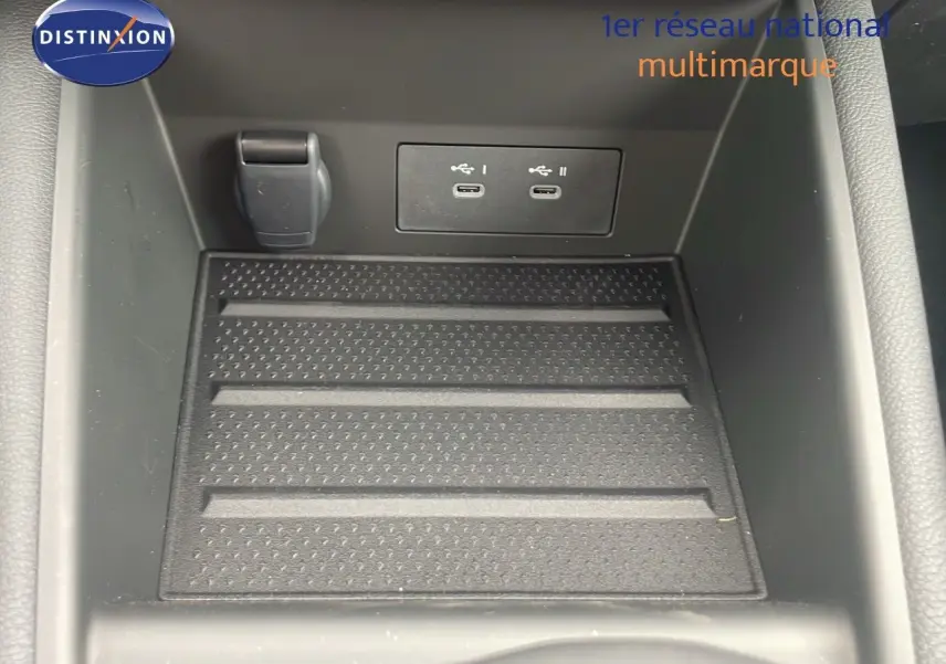 Gros plan sur la console centrale du Renault Captur E-Tech hybride 2025 avec ports USB-C et prise 12V.