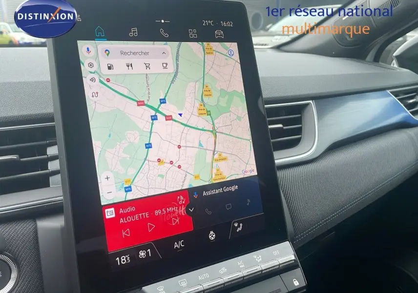Vue intérieure centrée sur l'écran tactile du tableau de bord du Renault Captur blanc nacré toit noir, affichant la navigation GPS.