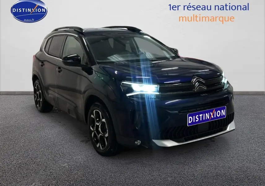 Vue 3/4 avant d'un Citroën C5 Aircross bleu eclipse avec phares LED allumés et jantes alu noires.