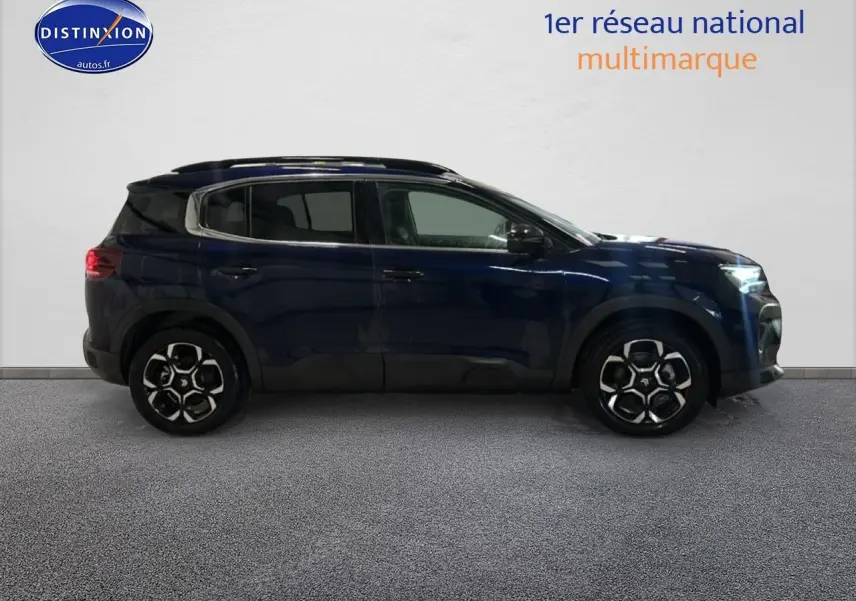 Vue de profil côté gauche d'un Citroën C5 Aircross bleu eclipse 2025 avec jantes alliage et barres de toit noires.