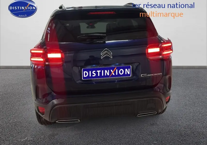 Vue arrière du Citroën C5 Aircross bleu eclipse avec feux arrière allumés et double sortie d'échappement visible.