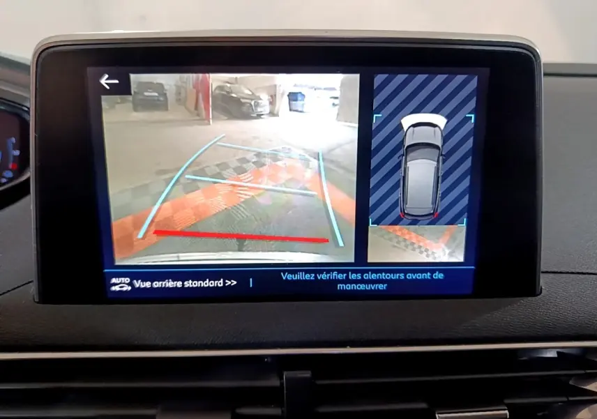 Écran tactile intérieur montrant la caméra de recul et l’aide au stationnement du Peugeot 3008 blanc hybride.