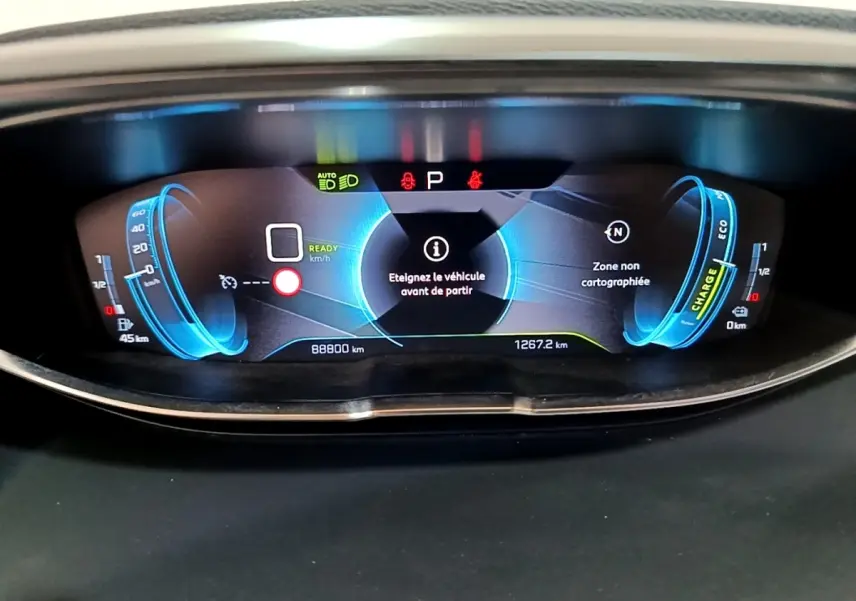Tableau de bord numérique du Peugeot 3008 hybride 2020, affichage bleu avec alertes et compteurs détaillés.