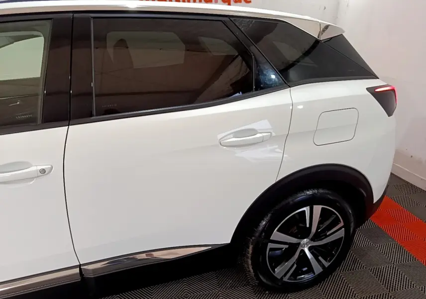 Vue latérale droite du Peugeot 3008 blanc hybride rechargeable, mettant en valeur la roue arrière et la trappe de recharge.
