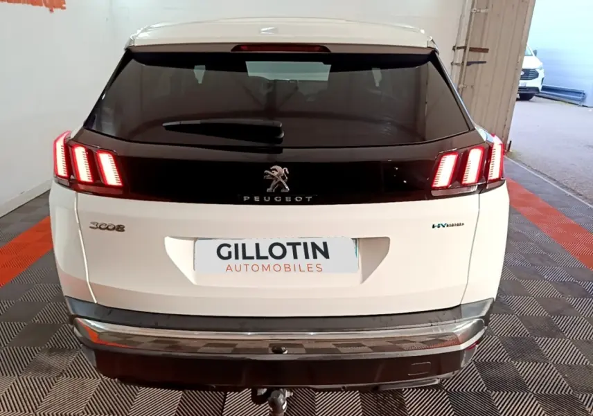 Vue arrière d'un Peugeot 3008 blanc hybride rechargeable avec feux LED allumés et logo central noir brillant.