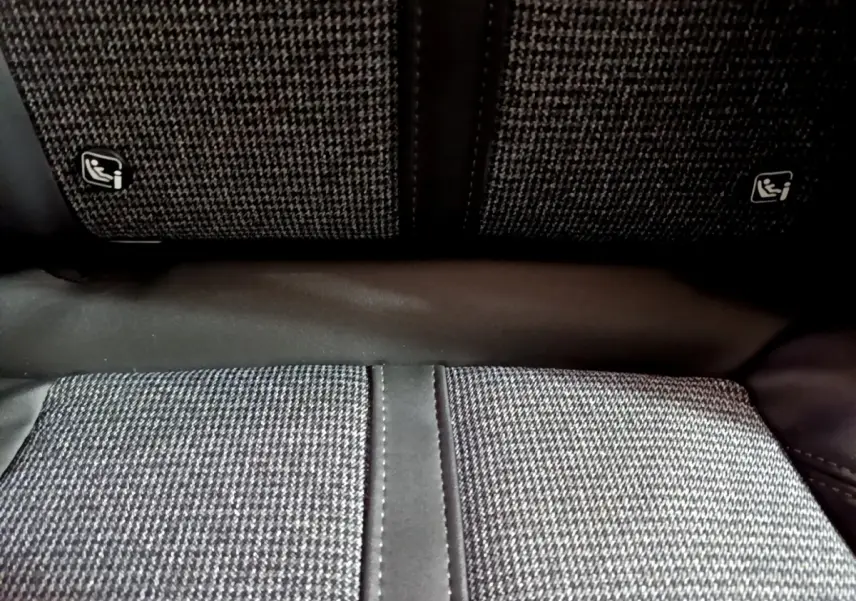 Gros plan sur la banquette arrière en tissu gris à motifs avec fixation Isofix visible sur un Peugeot 3008 blanc.