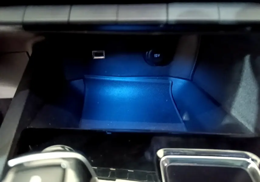 Gros plan sur la prise USB et prise 12V dans le rangement avant du Peugeot 3008 blanc hybride rechargeable.